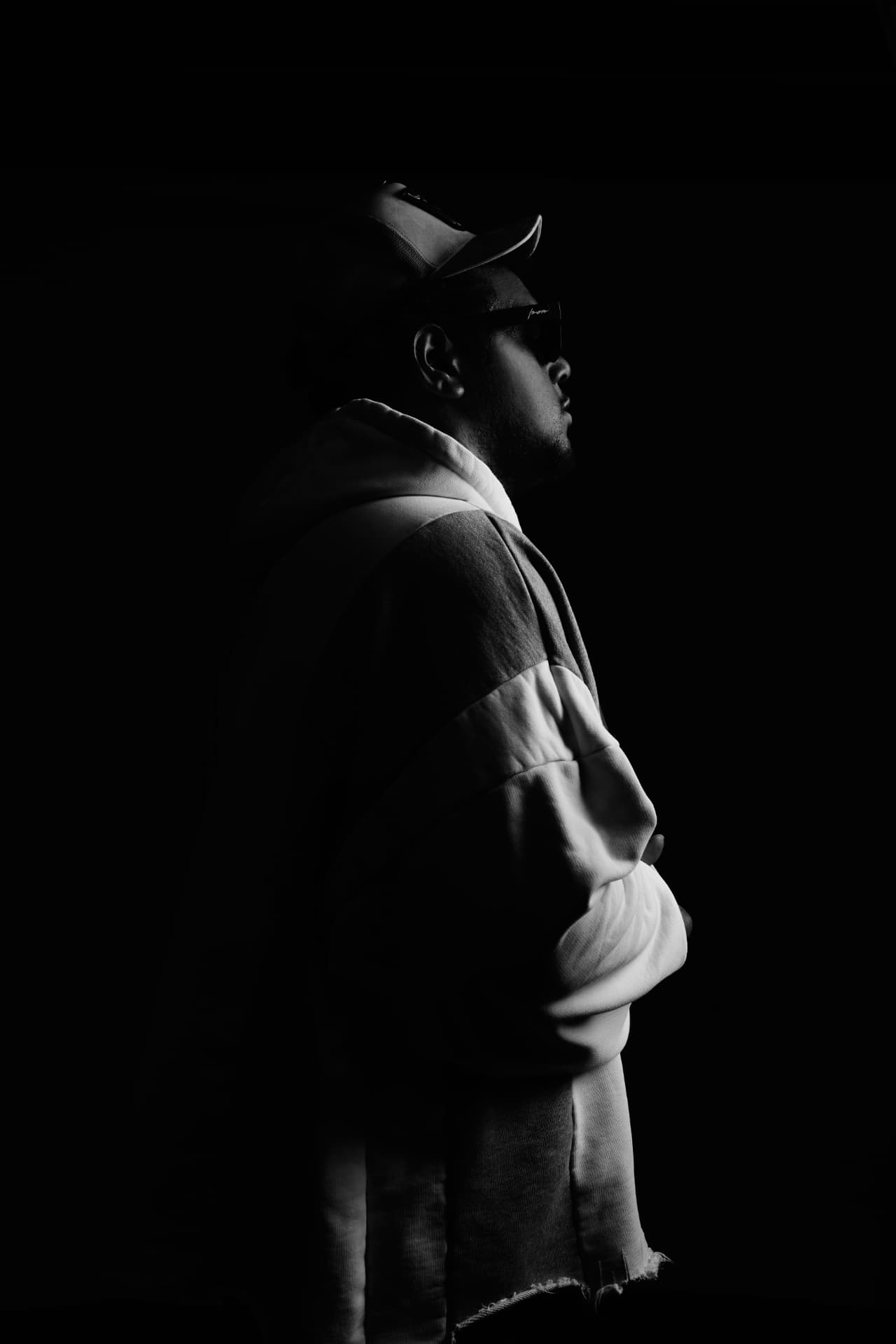 Black and white silhouette of YO.G.I in profile, lit from one side